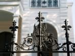An iron fence in front of an antebellum mansion in the New Orleans Garden District.