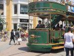 A historically styled trolley car tram carries passengers past shoppers and tourists at The Grove shopping center in Los Angeles