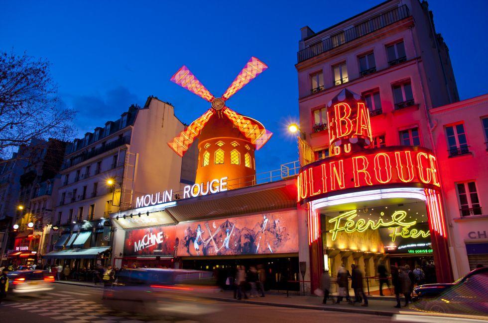 The Moulin Rouge by night, on March 3, 2010 in Paris, France. Moulin Rouge is a famous cabaret built in 1889 and is located in the Paris red-light district of Pigalle.