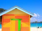 Bright yellow and orange wooden hut on the beach in the bahamas.