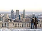 A couple looking toward downtown Montreal from Mont-Royal lookout in the winter.